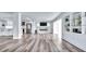Bright, open-concept living room features a fireplace, modern shelving and beautiful floors at 855 Bayway Blvd # 105, Clearwater, FL 33767