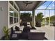Covered outdoor patio featuring comfortable seating, modern decor, and view to mature landscaping at 978 Signet Dr, Apollo Beach, FL 33572