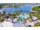 Aerial view of community pool, water slide, and docks on the lake with palm trees at 978 Signet Dr, Apollo Beach, FL 33572