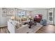 Bright living room with natural light, neutral-toned sofas, accent pillows, and a dark wood coffee table on soft rug at 10741 Hidden Banks Gln, Parrish, FL 34219