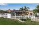 Backyard view with a screened pool area surrounded by a white fence and lush greenery at 127 Jennifer Dr, Rotonda West, FL 33947