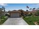 Attractive single-story home with lush landscaping, an American flag, and a spacious driveway at 127 Jennifer Dr, Rotonda West, FL 33947