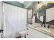 Stylish bathroom with a patterned shower curtain, a round mirror, and a white vanity at 1301 Jen Ma Jo Ln, Lutz, FL 33549