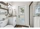 Well-lit bathroom features a tiled shower, a sink with a marble countertop, and backyard access at 1301 Jen Ma Jo Ln, Lutz, FL 33549
