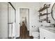 Well-lit bathroom features a tiled shower, shelving, a sink with a marble countertop, and tile floors at 1301 Jen Ma Jo Ln, Lutz, FL 33549