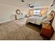 Spacious bedroom features natural lighting and decor, area rug, and ceiling fan at 1301 Jen Ma Jo Ln, Lutz, FL 33549