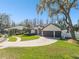 Charming home showcasing a three-car garage, circular driveway and manicured lawn at 1301 Jen Ma Jo Ln, Lutz, FL 33549