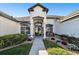 Charming home featuring a covered front entrance with decorative plants, a bench, and well-kept landscaping at 1301 Jen Ma Jo Ln, Lutz, FL 33549