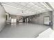 Spacious garage with epoxy flooring, storage cabinets, overhead lighting, and plenty of room for parking and storage at 1301 Jen Ma Jo Ln, Lutz, FL 33549