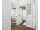 Hallway view leading to a bedroom and bathroom, accentuated by crisp white walls and sleek wood flooring at 1301 Jen Ma Jo Ln, Lutz, FL 33549