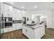 Well-lit kitchen with white cabinetry, a central island, stainless steel appliances, and dark hardwood flooring at 1301 Jen Ma Jo Ln, Lutz, FL 33549