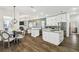 Open kitchen features island, white cabinets, stone countertops, and stainless appliances at 1301 Jen Ma Jo Ln, Lutz, FL 33549