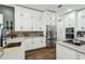 Charming kitchen with white cabinets, marble countertops, stainless appliances, and tile backsplash at 1301 Jen Ma Jo Ln, Lutz, FL 33549