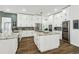 Gorgeous kitchen with white cabinetry, modern island, stainless appliances and a stylish backsplash at 1301 Jen Ma Jo Ln, Lutz, FL 33549