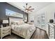 Relaxing main bedroom features a decorative ceiling fan, dark accent wall, and pool view at 1301 Jen Ma Jo Ln, Lutz, FL 33549