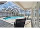 A covered, screened in pool with stone tile, and view of the water at 1301 Jen Ma Jo Ln, Lutz, FL 33549