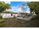 A fenced backyard with a stone fire pit and a lawn surrounded by trees at 13635 Coronado Dr, Spring Hill, FL 34609
