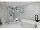 Bathroom featuring a freestanding tub and a glass enclosed shower with stylish marble tile surround at 13635 Coronado Dr, Spring Hill, FL 34609