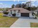 Exterior elevation view of a lovely single-story house with a green front lawn at 13635 Coronado Dr, Spring Hill, FL 34609