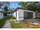 A detached one car garage with a black garage door, next to the yard at 13635 Coronado Dr, Spring Hill, FL 34609