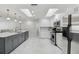 Modern kitchen with stainless steel appliances, white cabinets, gray island, and luxury finishes at 13635 Coronado Dr, Spring Hill, FL 34609