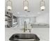 Kitchen island with a stainless steel sink and designer pendant lights overlooks the open floor plan at 13635 Coronado Dr, Spring Hill, FL 34609