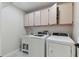 Functional laundry room features a modern washer and dryer and built-in cabinets at 13635 Coronado Dr, Spring Hill, FL 34609