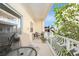 Balcony featuring wrought iron railings, seating, and views of lush trees and blue sky at 146 175Th Terrace E Dr, Redington Shores, FL 33708