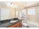 Bathroom with granite countertop, wooden cabinet, shower and tub combination, and decorative shower curtain at 146 175Th Terrace E Dr, Redington Shores, FL 33708