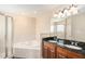 Bright bathroom features a soaking tub, glass shower, and double sink vanity with granite countertops at 146 175Th Terrace E Dr, Redington Shores, FL 33708