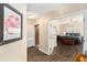 Hallway leading to a bright bedroom featuring hardwood floors and a decorative chest in front of the bed at 146 175Th Terrace E Dr, Redington Shores, FL 33708