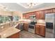 Bright kitchen with brown cabinets, granite countertops, stainless steel appliances, and outdoor views at 146 175Th Terrace E Dr, Redington Shores, FL 33708