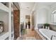 Bright bathroom with a soaking tub, tiled flooring, shower, and dark vanity at 15721 Starling Water Dr, Lithia, FL 33547