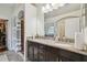 Bathroom featuring double sinks, granite countertop, dark cabinets, and a large mirror at 15721 Starling Water Dr, Lithia, FL 33547