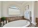 Bright bathroom featuring a soaking tub with tile surround and elegant fixtures at 15721 Starling Water Dr, Lithia, FL 33547