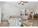Open living room showcasing a large sofa, statement wall paneling, ceiling fan, and hardwood floors at 15721 Starling Water Dr, Lithia, FL 33547