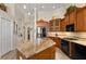 Gourmet kitchen with an island featuring granite countertops, pendant lighting, stainless steel appliances, and hardwood floors at 18149 Regents Square Dr, Tampa, FL 33647