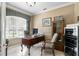 Comfortable home office featuring a wooden desk, tile flooring, and natural light from the window at 18149 Regents Square Dr, Tampa, FL 33647