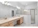 Bathroom featuring double sinks, vanity, a large mirror, and a glass-enclosed shower at 1847 Ravenridge St, Wesley Chapel, FL 33543