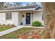 Close-up of the home's front door with a wreath, brick exterior, and manicured landscaping at 18802 Carr Dr, Lutz, FL 33559