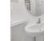 Bathroom with a white pedestal sink, round mirror, and modern fixtures at 21404 Darter Rd, Land O Lakes, FL 34638