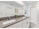 Modern bathroom featuring granite countertop, double sink, and a large mirror at 21404 Darter Rd, Land O Lakes, FL 34638