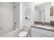 Bright bathroom features a white tiled shower, granite countertop, and window with blinds at 21404 Darter Rd, Land O Lakes, FL 34638