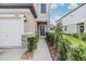 View of the front entry with a concrete walkway, well maintained landscaping, and a one car garage at 21404 Darter Rd, Land O Lakes, FL 34638