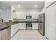 Bright kitchen featuring stainless steel appliances, granite countertops, and white cabinetry at 21404 Darter Rd, Land O Lakes, FL 34638
