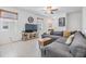 Living room with tile floors, a gray sofa, a ceiling fan, and a wall mounted TV at 21404 Darter Rd, Land O Lakes, FL 34638