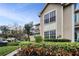 Well-maintained townhouse with manicured hedges, large windows, and charming curb appeal at 2180 Clover Hill Rd, Palm Harbor, FL 34683