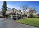 Charming home featuring a covered carport, inviting front lawn, and a picturesque setting under a clear blue sky at 2180 Clover Hill Rd, Palm Harbor, FL 34683