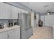 Bright kitchen featuring stainless steel refrigerator and neutral tile floors at 2180 Clover Hill Rd, Palm Harbor, FL 34683