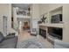 Open-concept living area showcasing a fireplace, staircase, balcony, and tile floors throughout the common areas at 2180 Clover Hill Rd, Palm Harbor, FL 34683